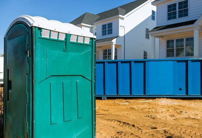 a line of portable bathrooms on a busy job site